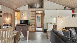 Een gezellig interieur met een eethoek, een bank, een televisie en een keuken.