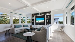 A modern living room with a large TV, two sofas, and a coffee table. - Sizzling Summer Rates at Surf Side Beach House  GULF VIEWS Elevator (Beach Retreats) (Holmes Beach)