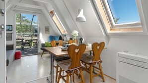 A modern loft bedroom with skylights, a dining area with heart-shaped chairs, and a view of the outdoors. - Beautiful home in Allinge with WiFi (Allinge)