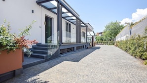 Un bâtiment moderne doté d’une façade en verre, d’un chemin pavé et d’espaces verts.
