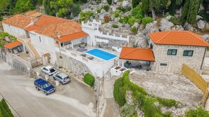 Une propriété située sur la côte, dotée d’une piscine, de bâtiments en pierre et d’un escalier menant à une terrasse.