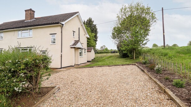 A house with a gravel driveway leading to a wooden gate. - 6 Hillside Cottages (Gainsborough)