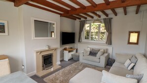 Ein Wohnzimmer mit Kamin, Sofa und Fernseher.