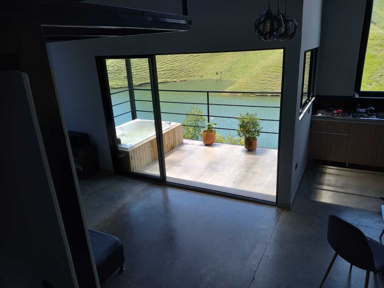 A modern kitchen with a large window overlooking a water body.