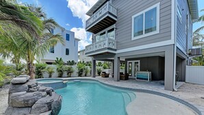 A modern two-story house with a swimming pool, outdoor furniture, and a covered patio area. - Mermaid's Landing managed by Beach Retreats (Bradenton Beach)