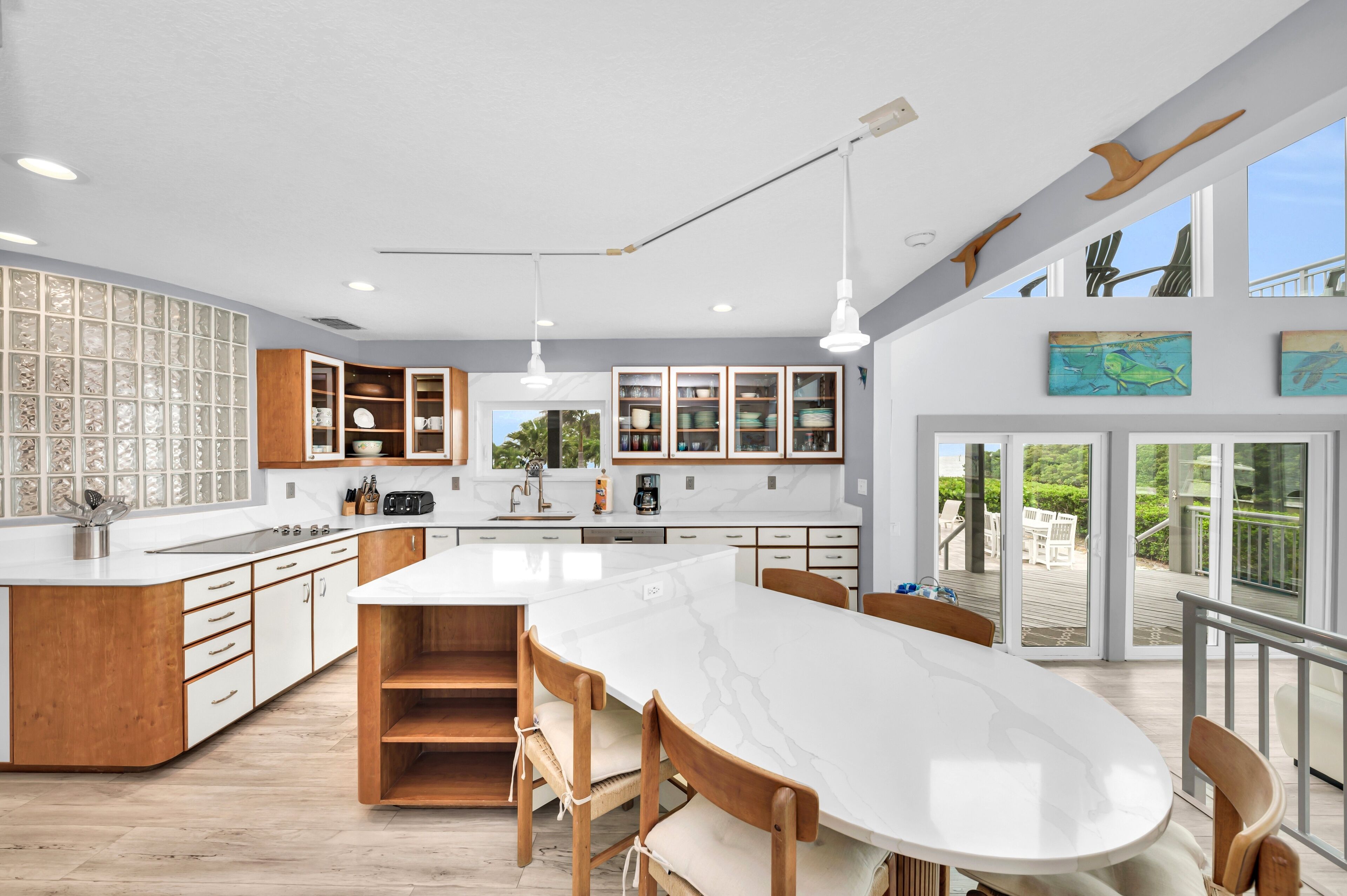 Una cocina moderna con una isla grande, armarios de madera y vistas al exterior.
