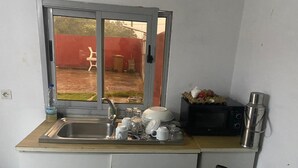 A compact kitchen with a sink, a stove, and a microwave.