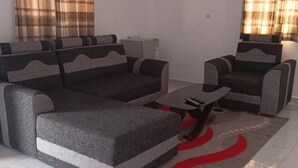A living room with a sofa set, a coffee table, and a patterned rug.