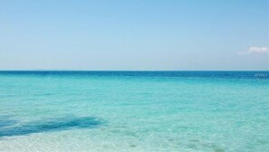 A clear view of a calm sea with a distant horizon.