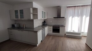 Une cuisine moderne avec des meubles blancs, un four à micro-ondes, une cuisinière et un lave-vaisselle.