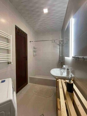 A modern bathroom with a bathtub, a sink, and a toilet.
