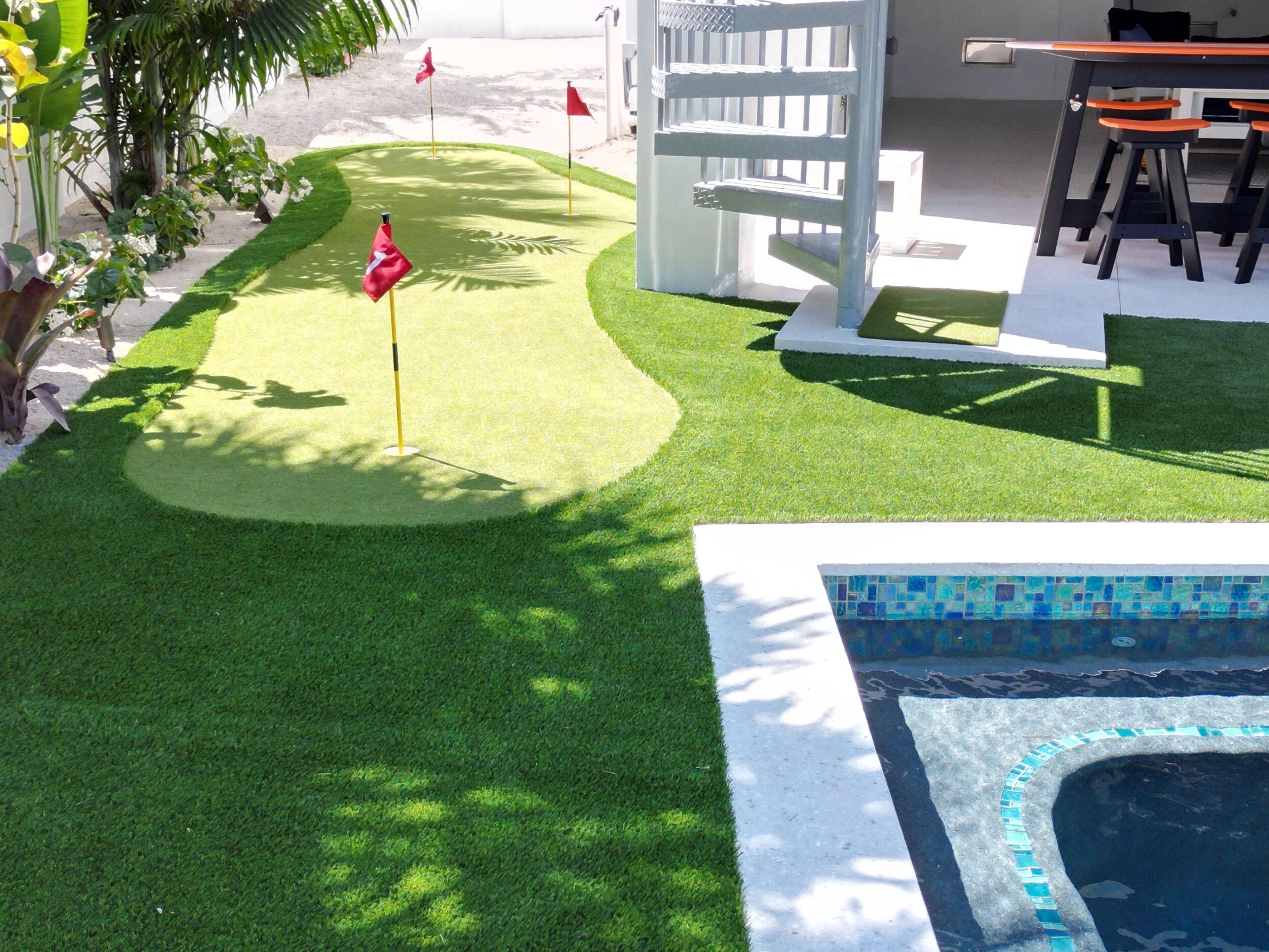 A miniature golf course with a pool in the foreground.