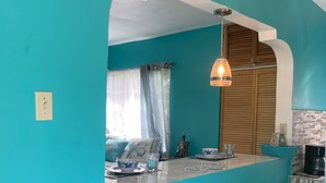 A kitchen with teal walls, a marble countertop, and a ceiling fan. - YanceyLargo Estate - Newly Built Modern 1 Bedroom Suite 1 Villa by RedAwning (Montego Bay)