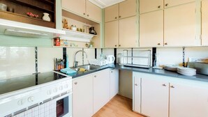 A kitchen with white cabinets, a stove, and a sink.