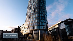 Moderni, kaareva rakennus, jossa on lasijulkisivu. Todennäköisesti hotelli, ja siinä on kyltti, jossa lukee: ”STAY YORKSHIRE” ja ”SERVICED ACCOMMODATION”.