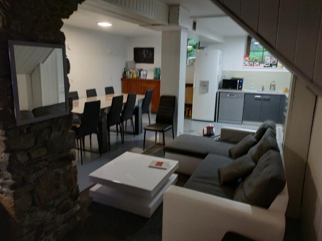 A modern living room with a sofa, coffee table, and dining area with chairs.