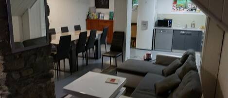 Una sala de estar moderna con sofá, mesa de centro y comedor con sillas.