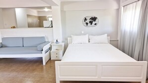 A bedroom with a bed, a sofa, a nightstand, and a wall-mounted globe. - My Cretan Village by Go4sea | Studio in Crete (Chorafakia)
