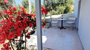 A covered outdoor patio with white tiled flooring, metal-framed chairs, and a table. - My Cretan Village by Go4sea | Studio in Crete (Chorafakia)