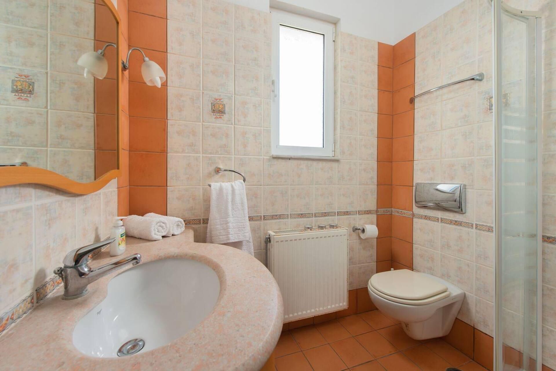 A bathroom with a sink, toilet, and shower.