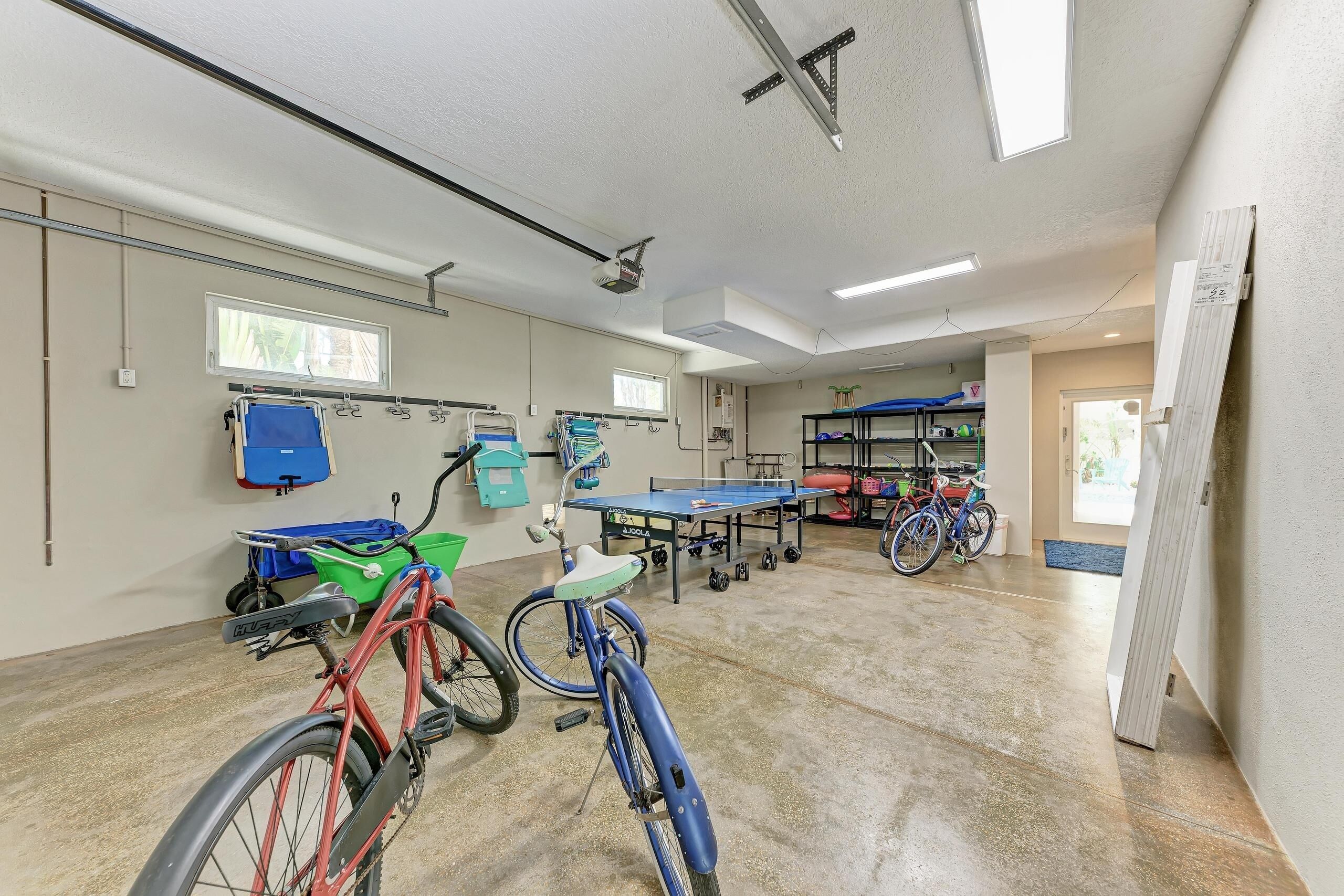 A spacious indoor area with bicycles, a ping pong table, and exercise equipment.