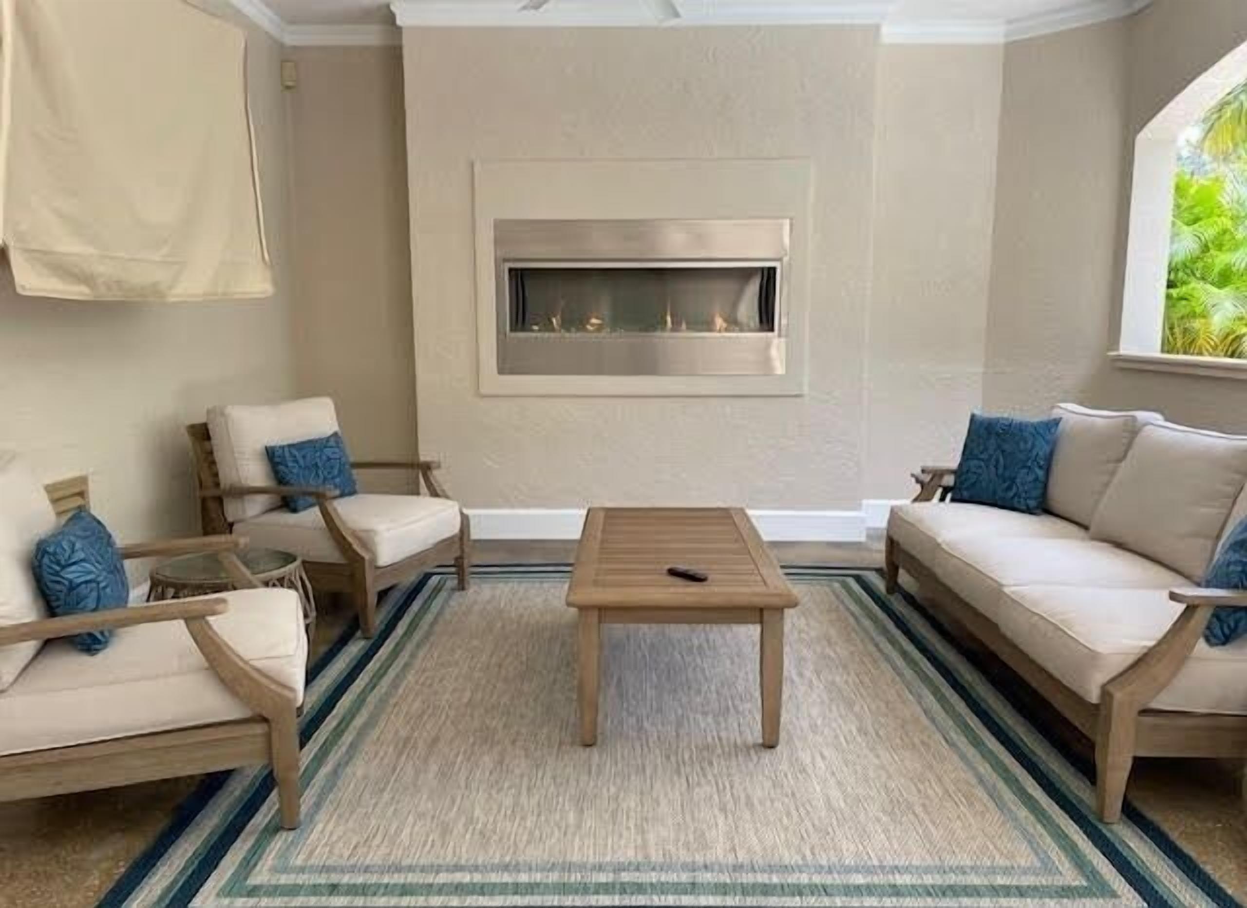A living room with a fireplace, two sofas, a coffee table, and a patterned rug.