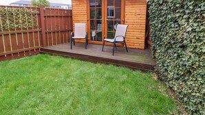 A wooden cabin with a deck, two chairs, and a glass door. - 2 Hartburn Road (North Shields)
