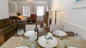 A dining area with a table set for four, a chandelier, and a view into the living room. - 2 Hartburn Road (North Shields)