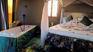 Quarto com cama, banheira e janela.