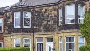 A row of terraced houses with bay windows and a traditional design. - Ground Floor Victorian Apartment (Coatbridge)