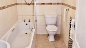 A bathroom with a bathtub, toilet, and shower. - Ground Floor Victorian Apartment (Coatbridge)