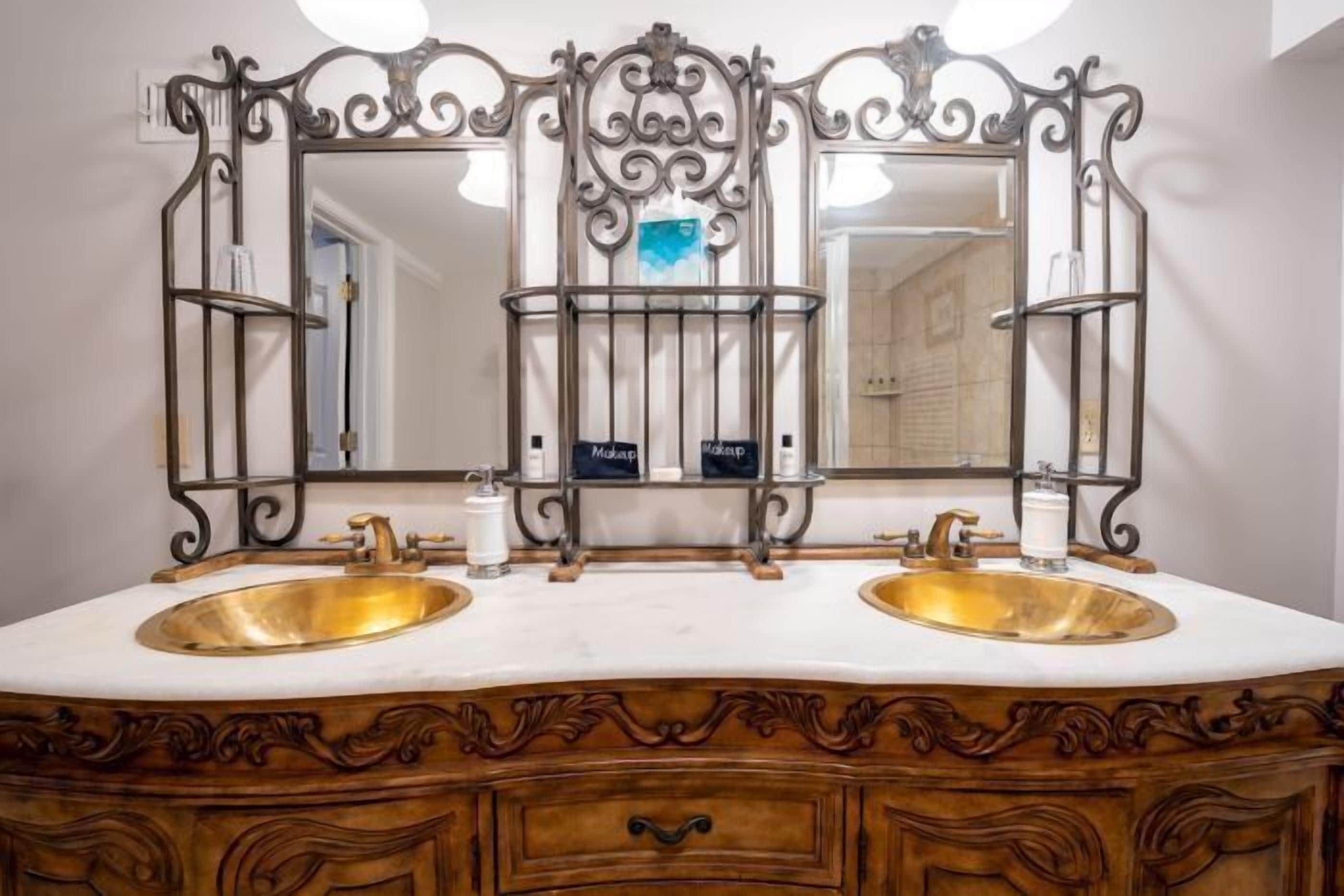 A bathroom with two sinks, a large mirror, and a vanity with drawers.