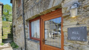 A stone building with a wooden door and a sign that reads "Mill House." - Mill House (Lostwithiel)
