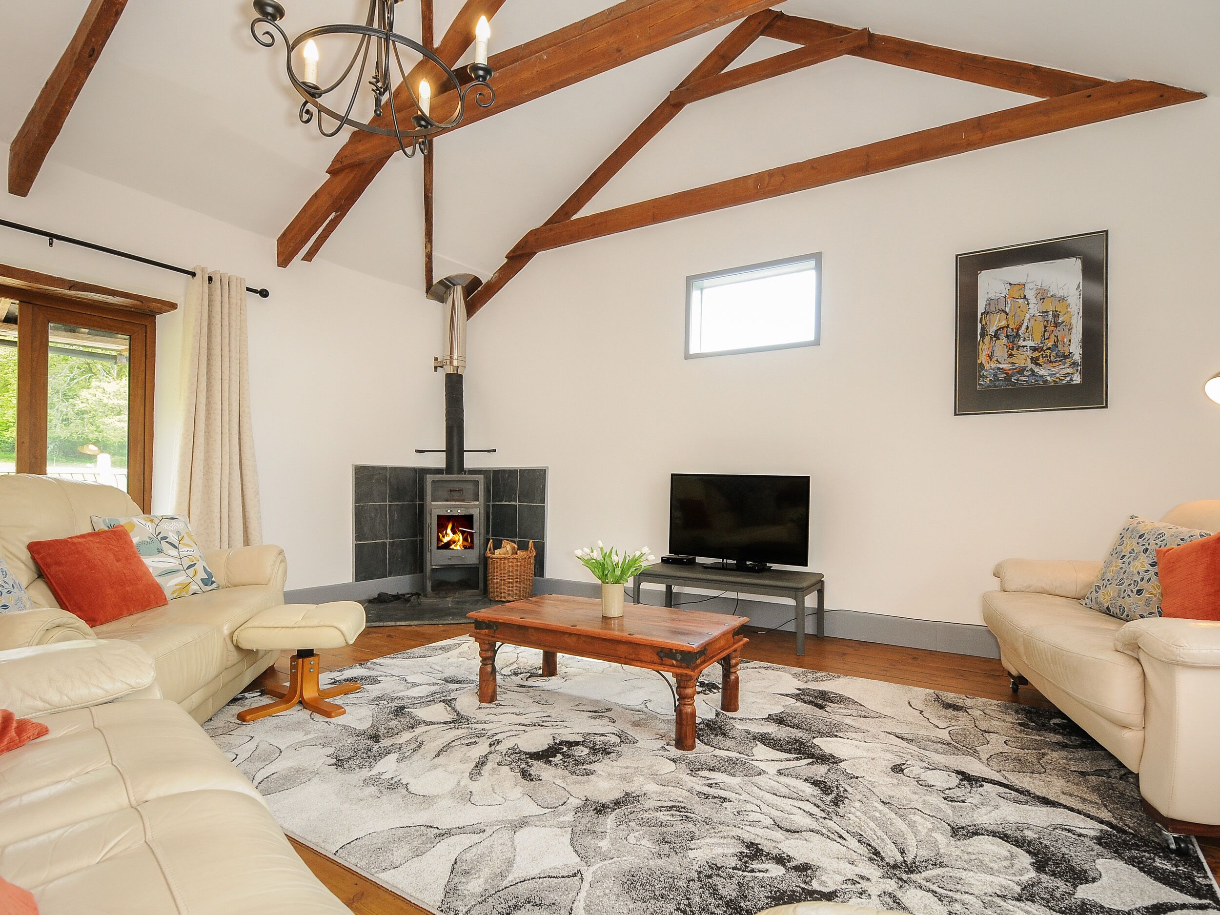 A living room with a fireplace, a television, and two sofas.