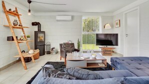 A modern living room with a wooden ladder, a fireplace, a television, and a sofa. - Stunning home in Otterup with WiFi (Otterup)