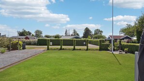 A well-maintained lawn with a metal fence and a gravel path. - Stunning home in Otterup with WiFi (Otterup)