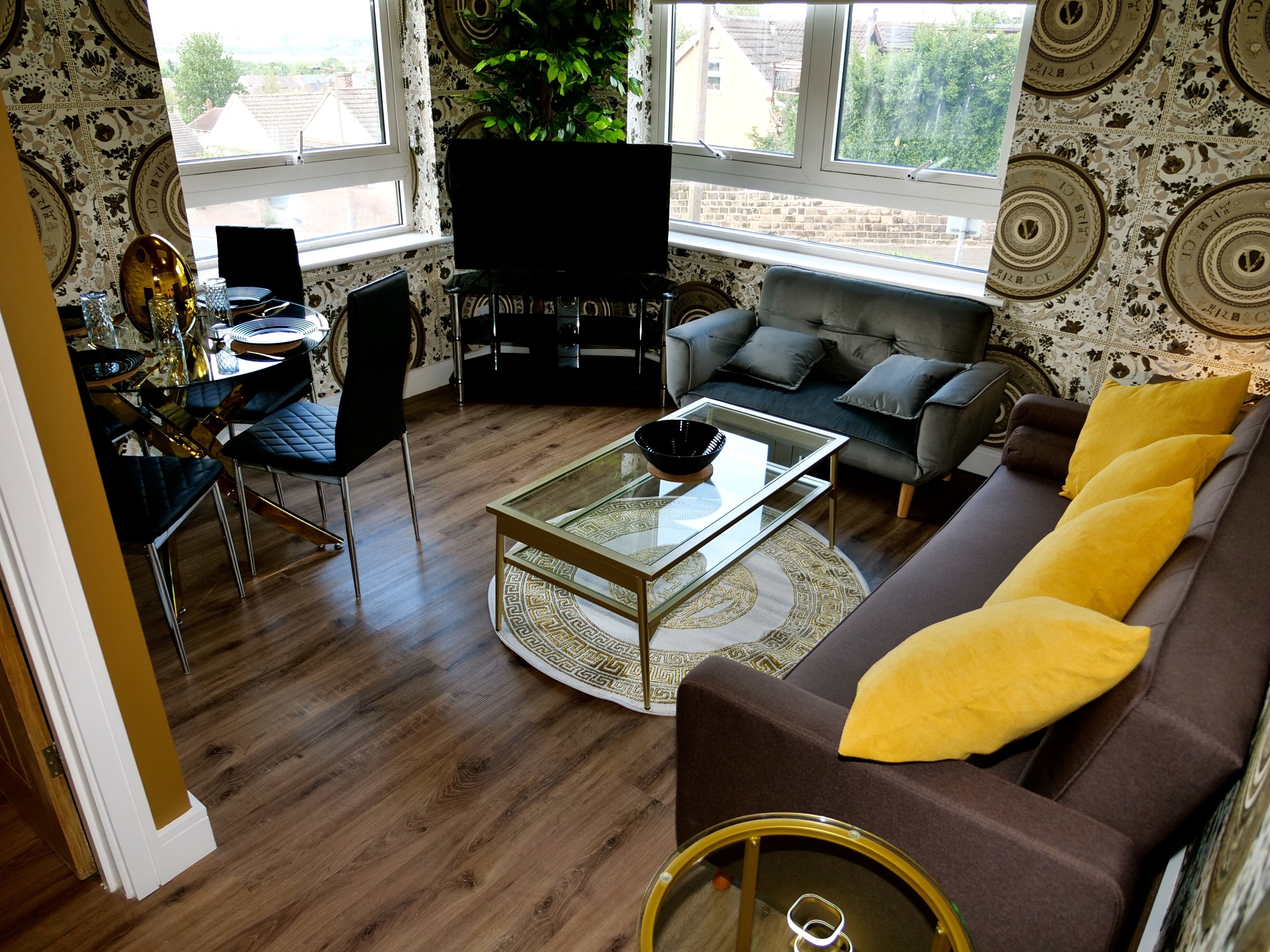 A modern living room with a sofa, coffee table, and a dining area with chairs and a table.