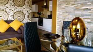Un salon moderne avec un canapé, une table basse en verre et une horloge murale décorative.