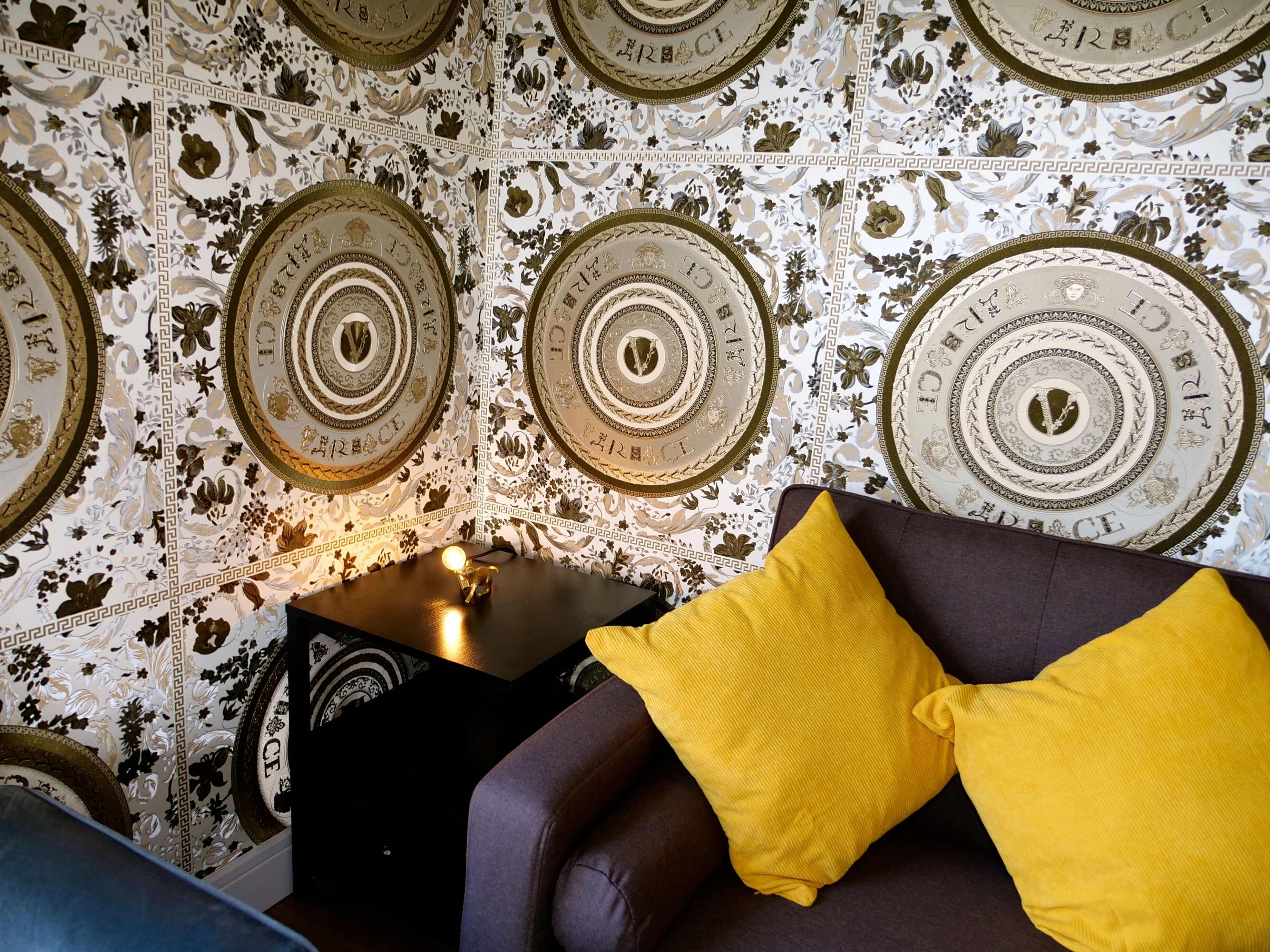 Una habitación con papel tapiz decorado con diseños circulares y la palabra 'GRACE'.