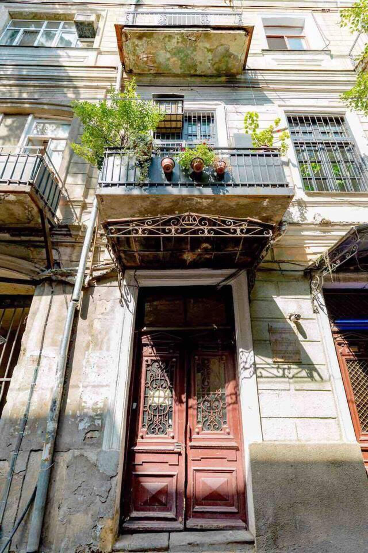 A building with a traditional facade, featuring a prominent entrance with a wooden door and a balcony above.