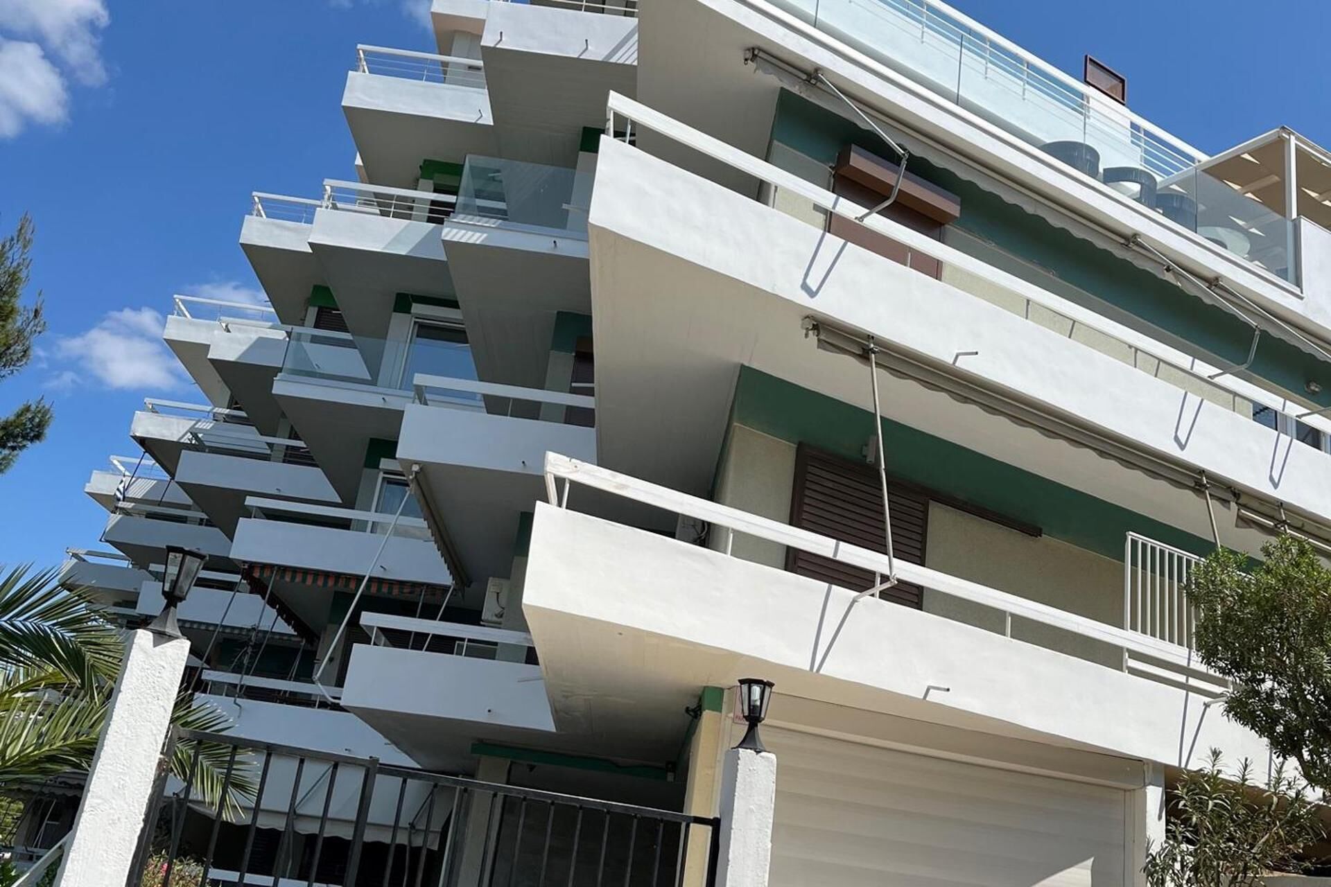 Um edifício residencial com vários andares, varandas e telhado plano.