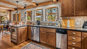 Una cucina moderna con mobili in legno, elettrodomestici in acciaio inossidabile e un'ampia finestra che si affaccia su un panorama suggestivo.