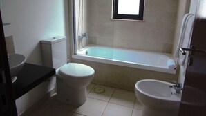 A bathroom with a toilet, bidet, and bathtub. - Lovely 2-bed Apartment in Santa Maria (Sal)