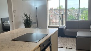 A modern kitchen with a large island, built-in oven, and a view of the city through large windows. - Immaculate 2-bed Apartment in London (London)