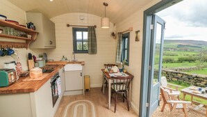 Eine gemütliche Küche mit Holzausstattung, einem Spülbecken und einem Fenster mit Blick auf eine reizvolle Landschaft.
