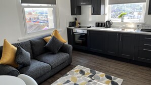 Una cucina moderna con mobili scuri, forno integrato e una finestra con vista sulla città.