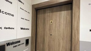 Une porte en bois portant une étiquette « A » et dotée d’un système de verrouillage à clavier.