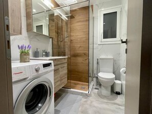 Studio | Badkamer | Een douche, een haardroger, handdoeken