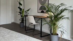 Un salon moderne avec une table en bois, une chaise blanche et deux plantes en pot.