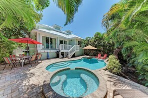 A house with a swimming pool, outdoor furniture, and lush greenery. - Turtle's Bay managed by Beach Retreats (Holmes Beach)